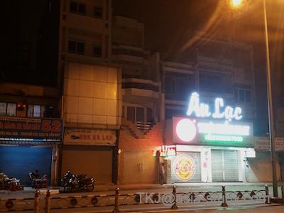 ホーチミンの夜の大通り。ネオンが光る店舗とバイクが並ぶ街角