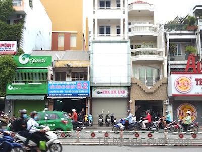 昼の大通り沿いの店舗列。バイクが多いホーチミンの街並み