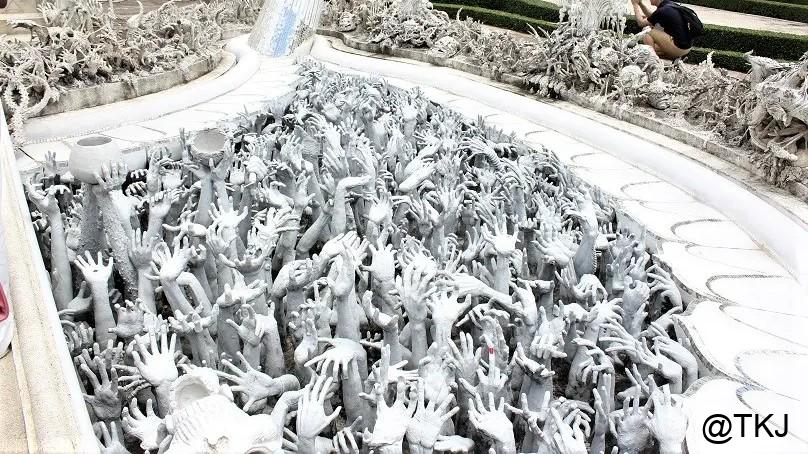 白い寺院の地獄モチーフ展示。地面から無数の手が伸びるオブジェが密集しているエリア