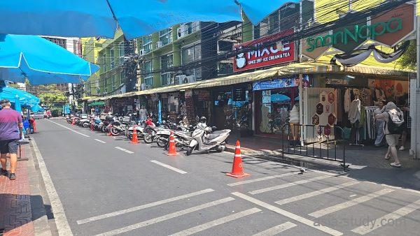 青いパラソルが続く通り、路肩にバイクがずらっと駐車