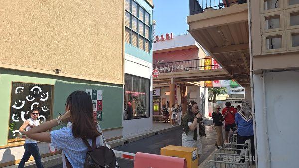 商業施設の中庭、通路奥に人が行き交うショッピングエリア