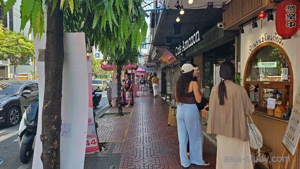 歩道沿いのCafé Amazon、店先に立つ人と通りの雰囲気