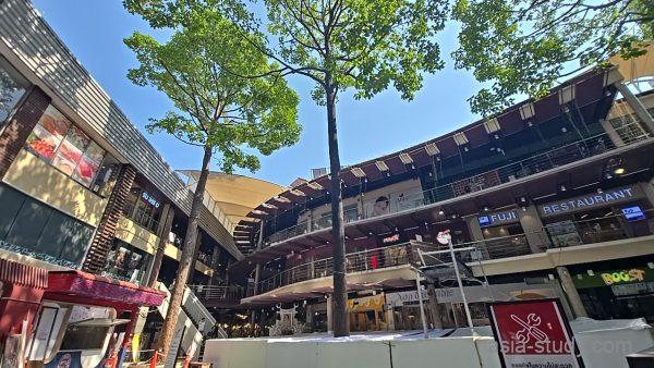 ショッピング施設の外観、FUJI RESTAURANTの看板が見える中庭