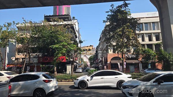 高架下の通りから見た街並み、奥にアーチ状の看板が見える