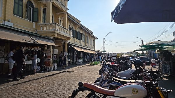黄色い建物沿いにバイクが並ぶターティアン周辺の通りと人の流れ