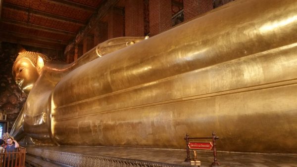 ワットポーの巨大な涅槃仏（寝仏像）を足元からの写真。左下に人。