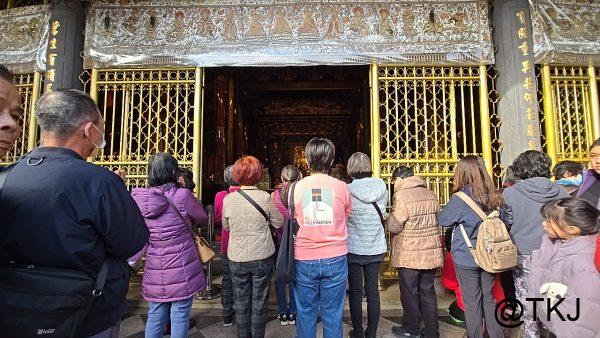 龍山寺の本殿入口｜金色の門扉前に並ぶ参拝客と、奥に見える拝殿の雰囲気
