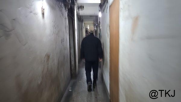 狭い通路を歩く人、白い壁に挟まれた“怪しい”細道の雰囲気（台北・萬華）