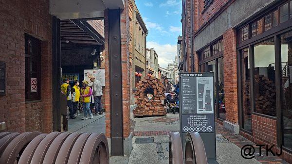 剝皮寮歴史街区の入口付近、黄色いジャンパーの係員が立つ案内ポイント（台北・萬華）