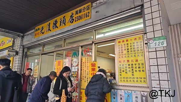 広州街の饅頭店の外観、店頭メニューと購入待ちの人（台北・萬華）