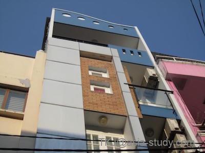 Quy Thanh Hotelの建物外観。細長いホテルビルを見上げた青空の写真