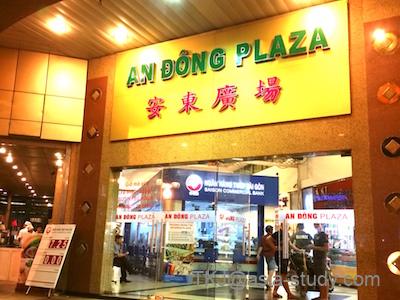 ホーチミン「AN DONG PLAZA（安東広場）」の入口。夜の看板とガラス扉のエントランス