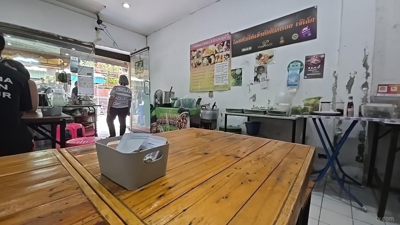 ローカル食堂の店内、木のテーブルと壁のメニュー掲示