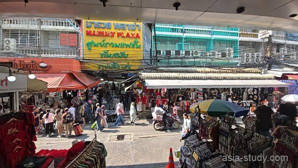 プラトゥーナム市場の入口付近を上から見下ろす、看板と人波が交差する通り