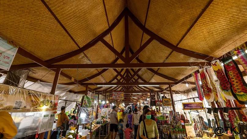 週末マーケットの屋台通路、屋根付きの通路に店が並ぶローカルな雰囲気