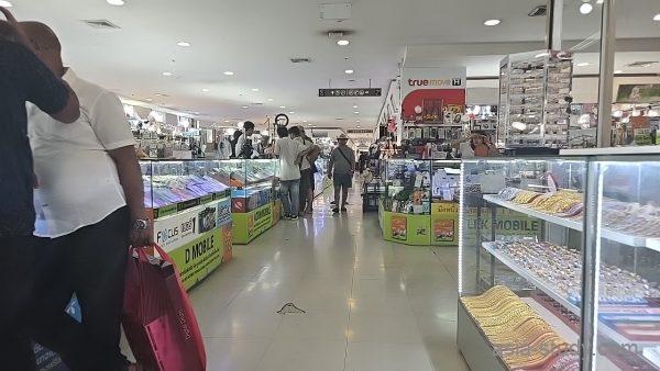 商業ビルの通路、スマホ関連ショップとガラスケースの並ぶフロア