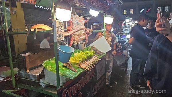 カオサン通り名物、ワニの丸焼きがディスプレイされたワニ肉バーベキューの屋台