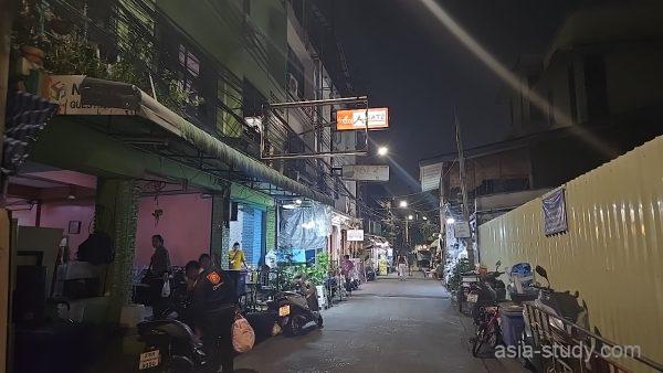 「NAT 2 GUEST HOUSE」の看板が灯る、夜のゲストハウス街の通り