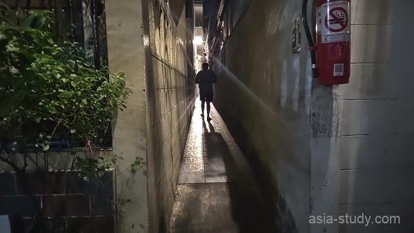 人ひとりがやっと通れるほど狭く、奥に街灯の光が差し込むカオサンの暗い路地裏