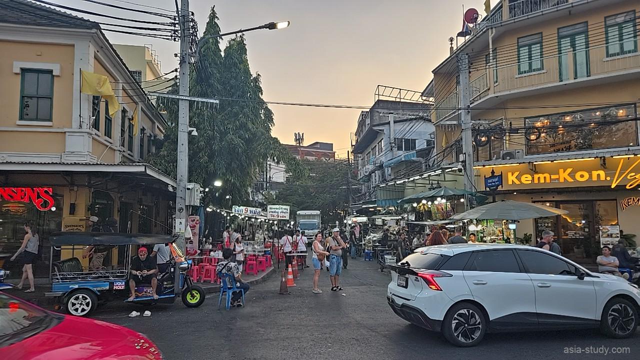 夕暮れ時のカオサン周辺の交差点、トゥクトゥクとKem-Konの看板が見える街角
