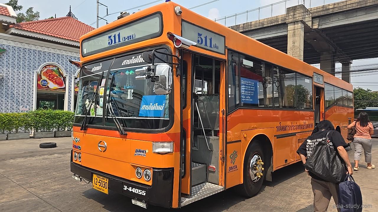 オレンジ色の路線バス511番、ターミナルで乗客が乗り込む場面