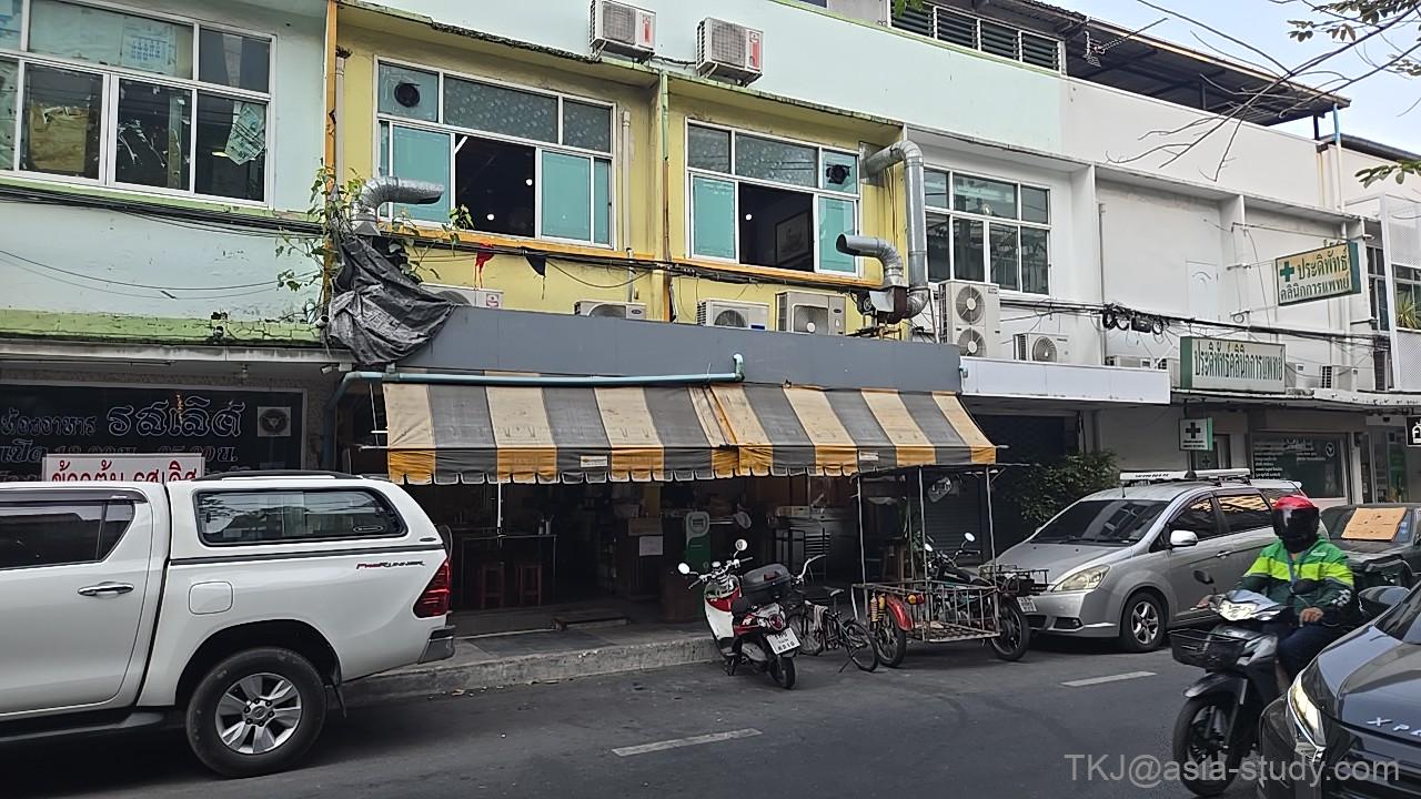 縞模様のひさしがある食堂の外観と前の通り(車・バイク)