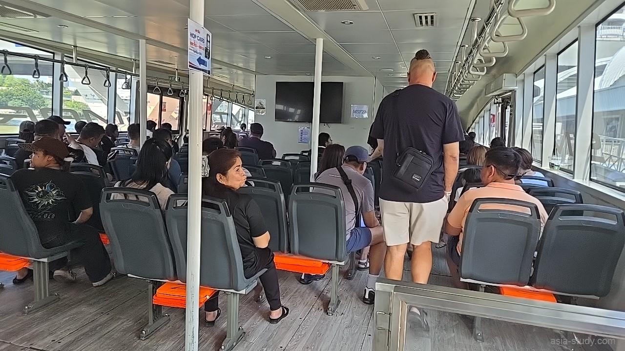 「MINE SMART FERRY」の船内、清潔なグレーの座席とオレンジ色のライフジャケットが備え付けられた客室の風景