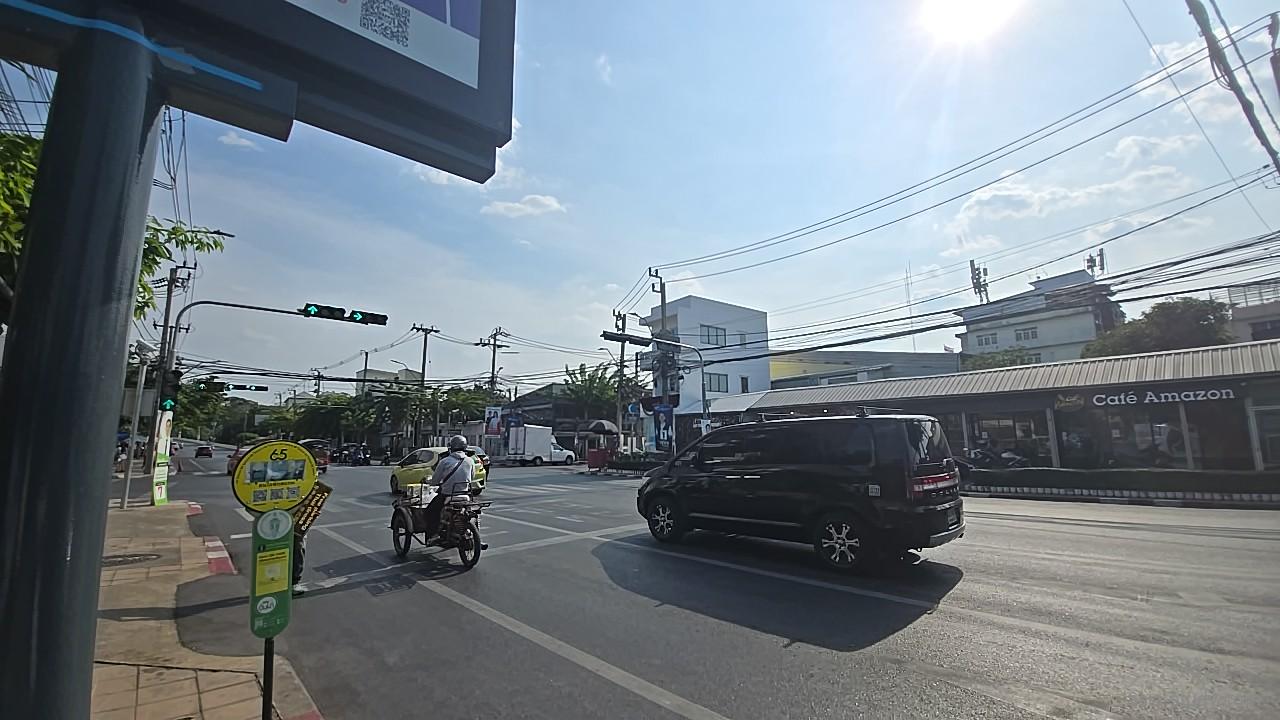 カフェ・アマゾン（Café Amazon）が見えるバンコクの交差点、サイドカー付きのバイクが走り抜ける日常の風景