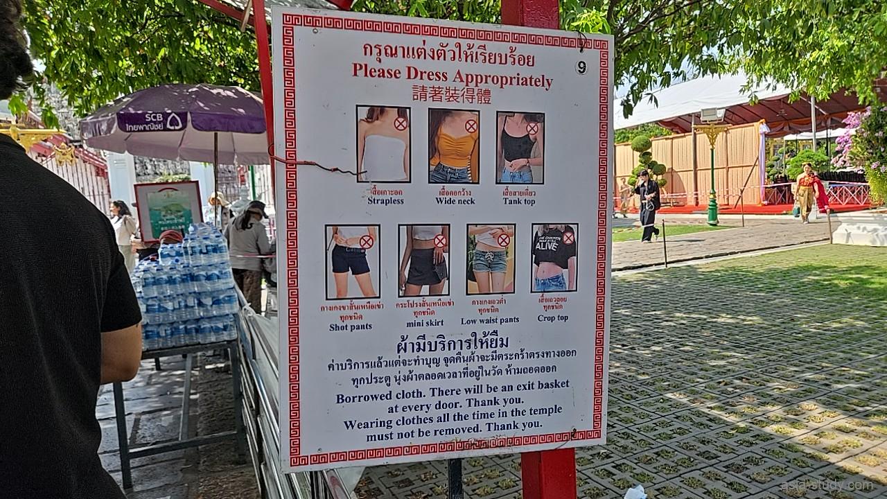 「Please Dress Appropriately」と書かれた、寺院拝観に不適切な露出の多い服装をイラストで示す案内板のアップ