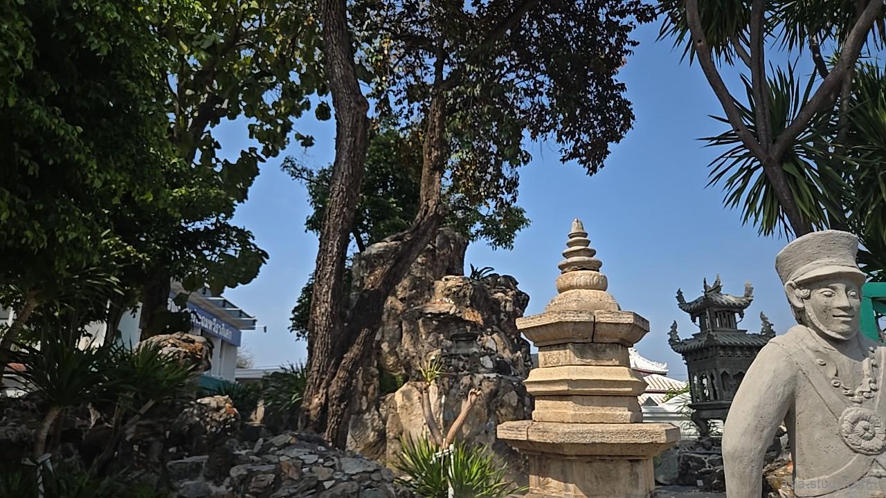 境内の庭園にある石像。西洋の帽子をかぶったようなユニークな石像と、背景にある奇岩のディスプレイ