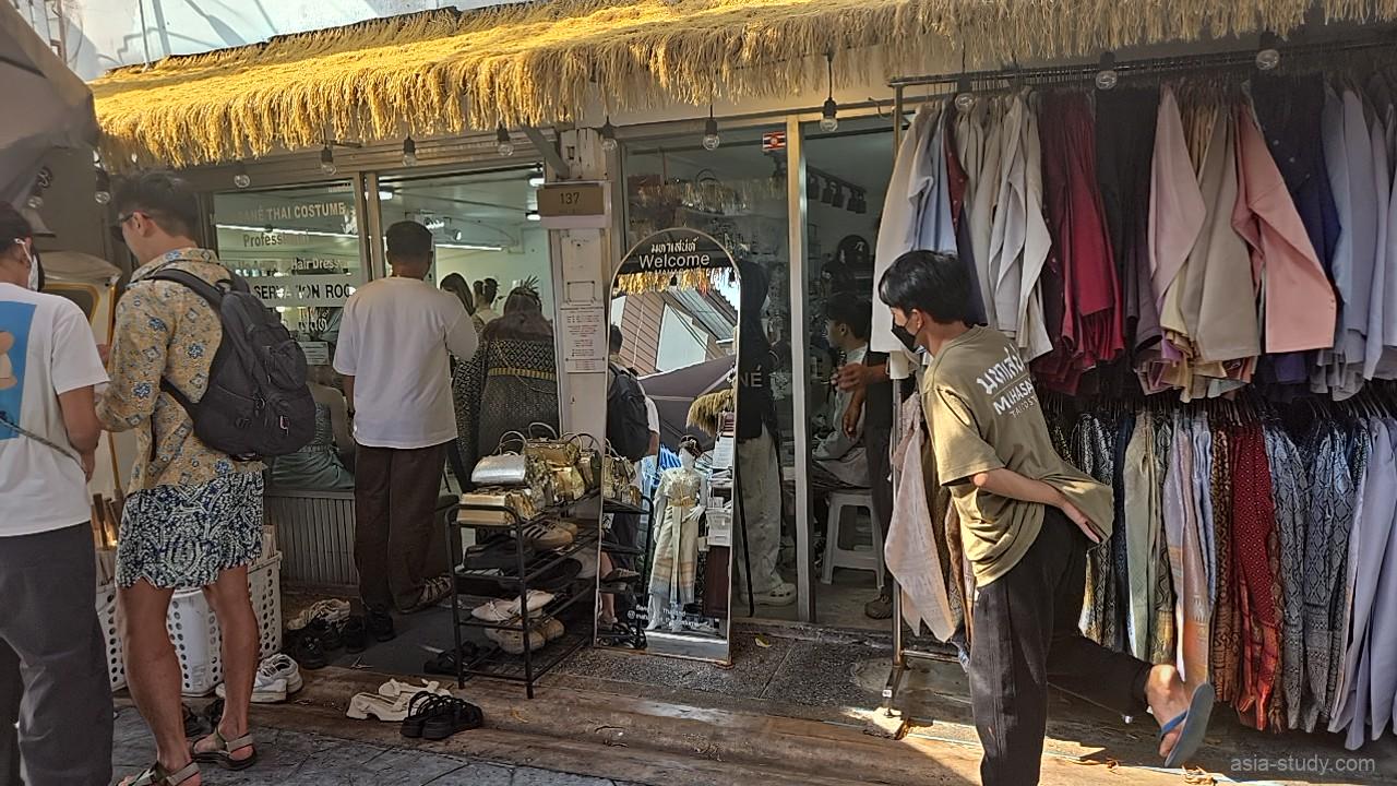 タイの伝統衣装レンタル店「Mahasane Thai Costume」の店頭、色鮮やかな衣装が並ぶラックと衣装を選ぶ観光客やスタッフの様子