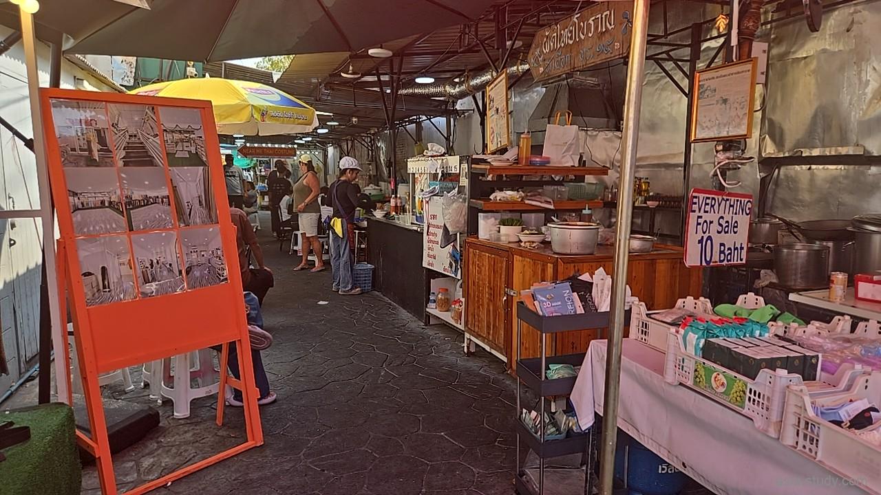 「Everything For Sale 10 Baht」の看板が掲げられたオープンエアの飲食店、調理器具や食材が並ぶローカルな厨房エリアの様子
