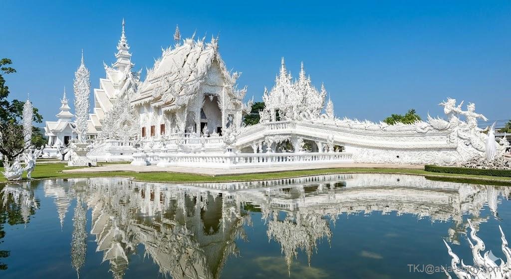 タイ・チェンライを象徴する白い寺（ワット・ロンクン）。精巧な白い彫刻と水面への映り込み。