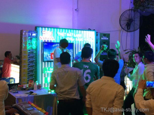 ステージ前に人だかりができ、手を上げて参加するホーチミンの夜イベント風景（LEDパネルが光る）