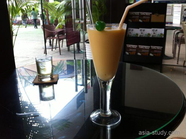 ガラスの丸テーブルに置かれたドリンク、ストローとチェリー飾り