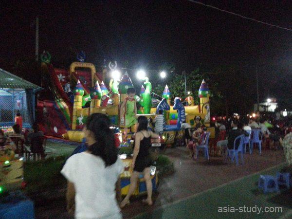 夜の移動式遊具エリア（子ども向けの巨大エア遊具と周辺の屋台）
