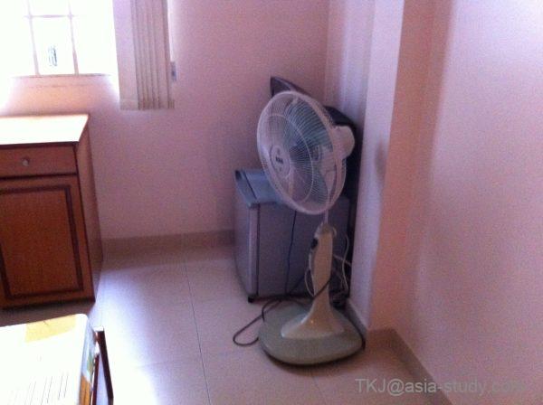 扇風機と小型冷蔵庫が置かれた部屋の一角