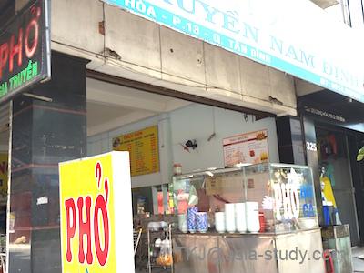 ホーチミンのフォー店の外観（看板「PHO」と屋台カウンター）