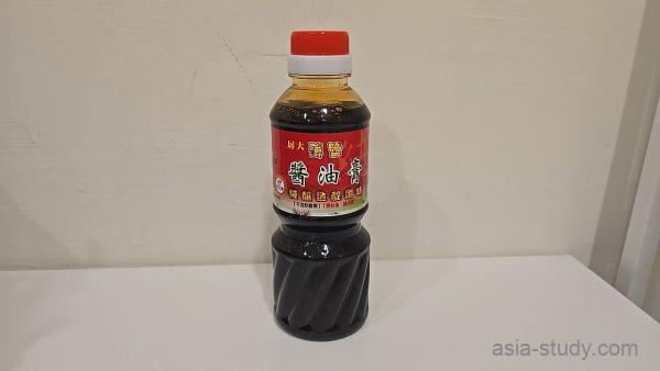 赤いラベルの醤油膏ボトルを白い棚に置いて撮影（購入品）