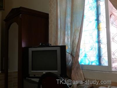 客室のテレビとクローゼット。カーテン越しの窓から光が入る