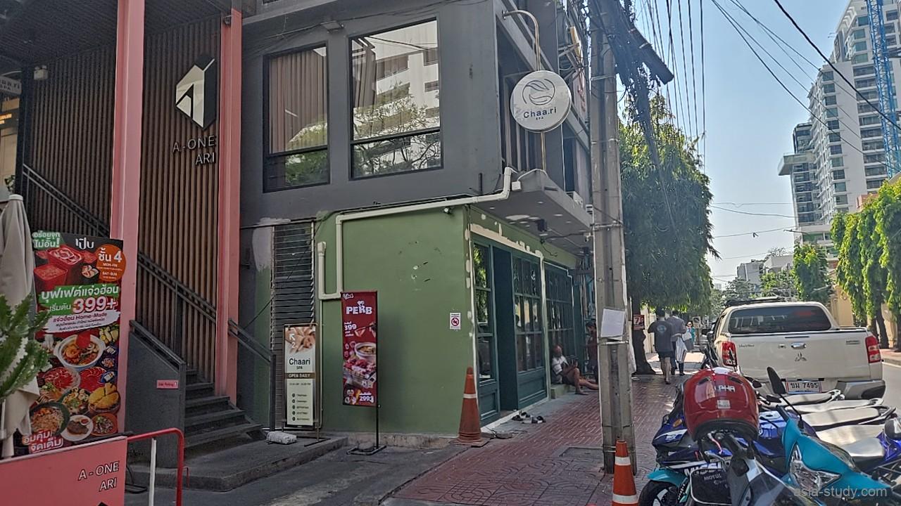バンコクのアーリー・ソイ1にある、お茶の癒やしをコンセプトにした「Chaari Spa（チャーリスパ）」の店舗正面。白を基調とした清潔感のある外観に、木製フレームのドアと大きなガラス窓が配された隠れ家のような佇まい。
