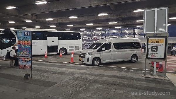 スワンナプーム空港のバス乗り場、長距離バスと白いバン（S1案内）