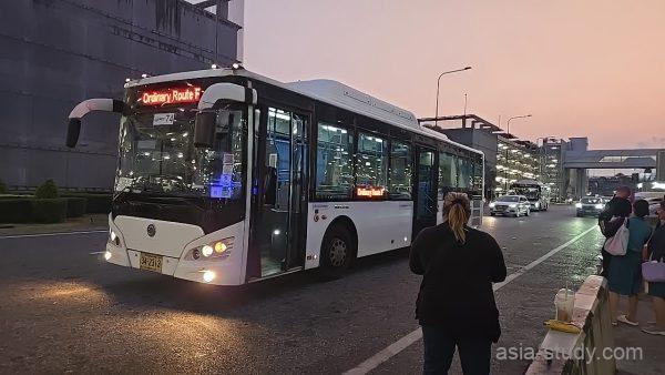 スワンナプーム空港の路線バス停留所、夕暮れのバスと待つ乗客