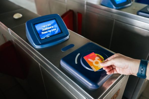 BTS改札機のカードリーダーにラビットカードをかざすシーン