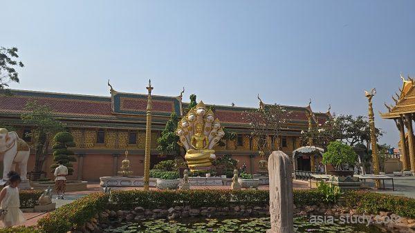 中庭の池越しに見えるナーガに守られた金色の仏像オブジェ