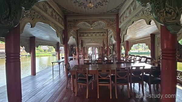 水上マーケットの食事スペース（木造の屋根付きテラスとテーブル席）