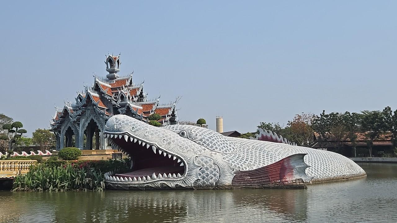 口を開けた巨大ワニの像と、奥の寺院風建物（アンシエント・シティ）