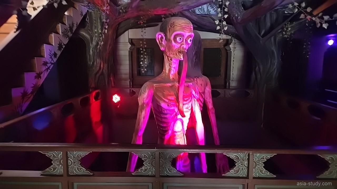暗い館内でピンクに照らされた不気味な人型オブジェ（Ghost Museum）