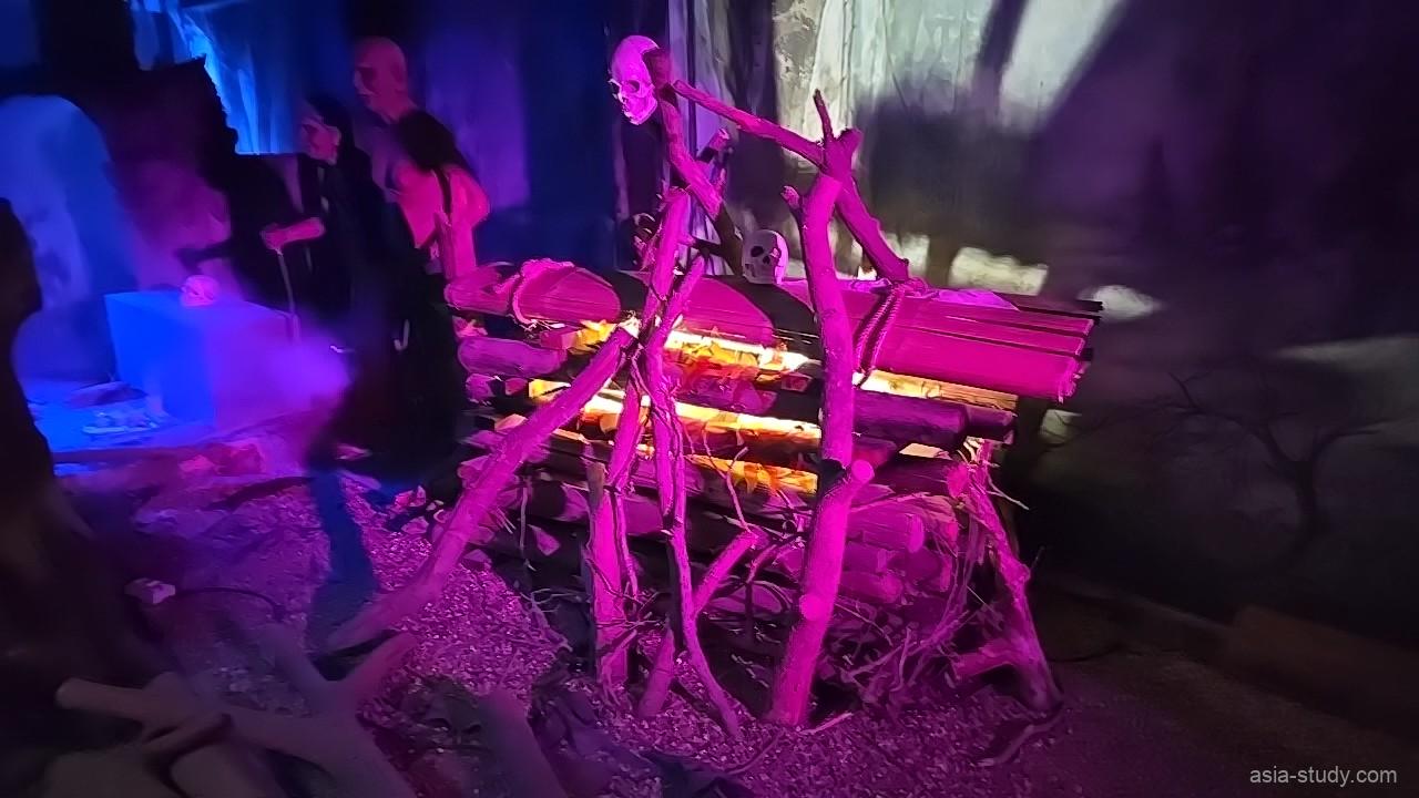 紫の照明と骨組みの展示、焚き火風の演出（Ghost Museum）