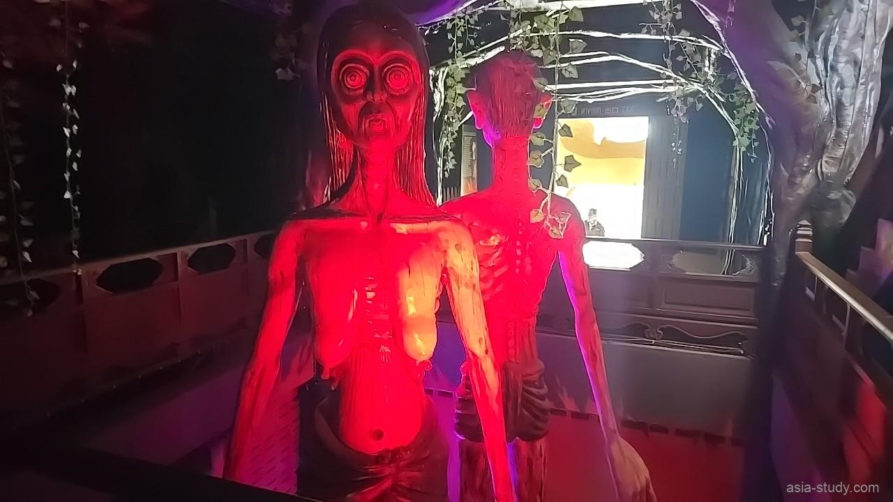 赤いライトで照らされたホラー人形と通路（Ghost Museum）